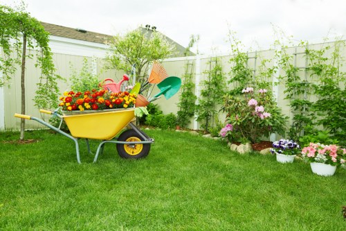 Local gardener trimming hedges and maintaining a small urban garden in North Kensington